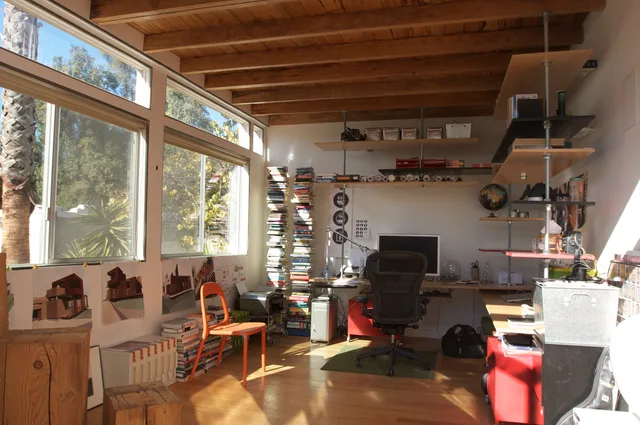 Home Office with custom built furniture made by recycling the leftover building materials from the addition. Adjustable plywood shelves and desks are hung from the ceiling on threaded rods, leaving the floor space clear. The ceiling is vaulted and the West wall carved with openings to bathe the room. How Seattle sustainable venture rules affect home-based business costs